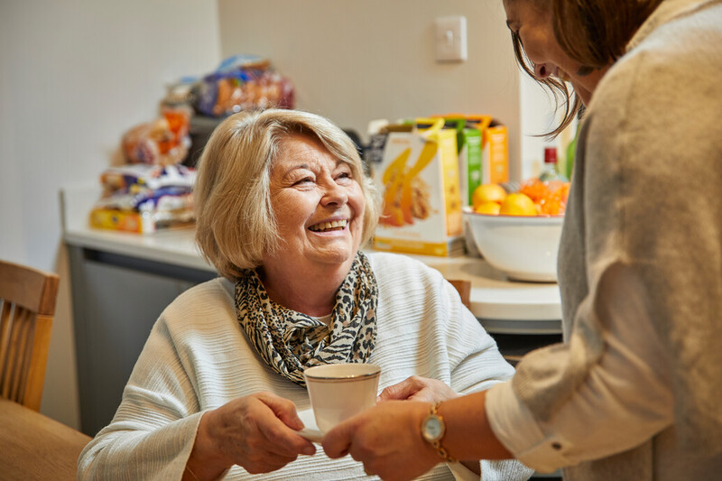 A photo of someone handing another person a cup of tea