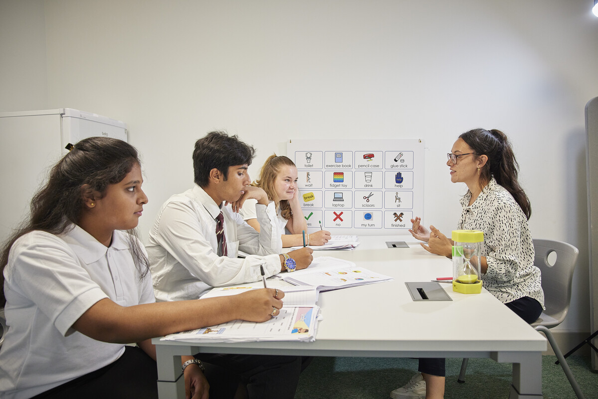 Group of teenagers talking to a staff member