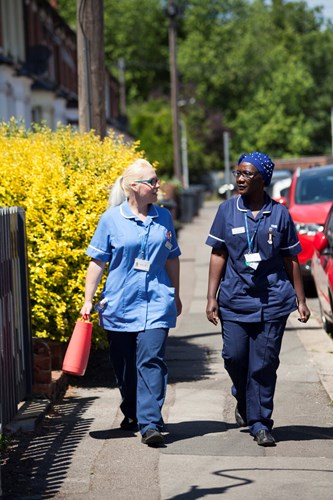 two community staf walking in the street