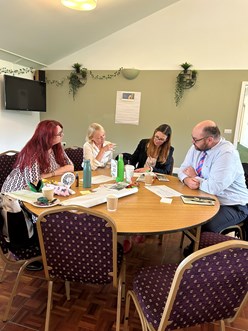 A group of people sat around a table sharing ideas
