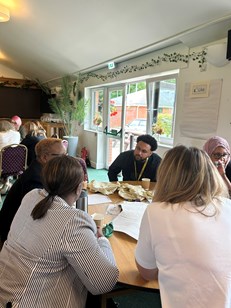 A groupp of people sat at a table talking.