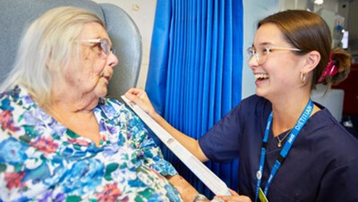 A staff member talking to a patient bedside