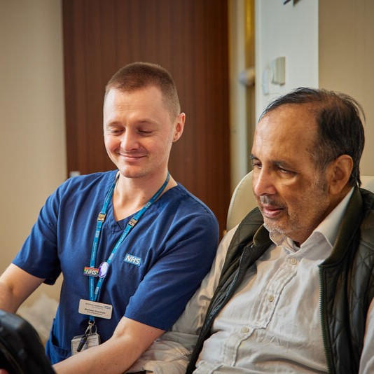 Staff member and patient looking at tablet together