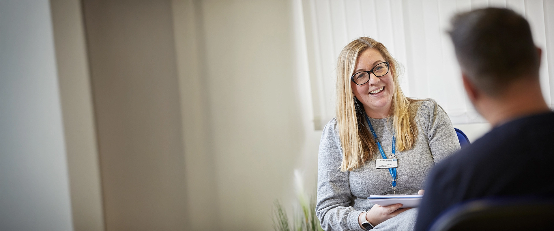A staff member smiling while interviewing a person