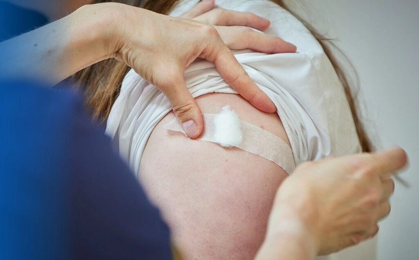 Arm with cotton bud after having a vaccine