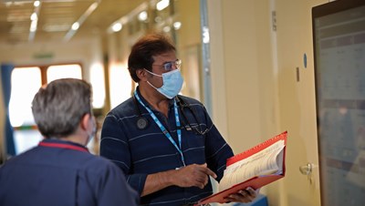 Two people wearing PPE masks