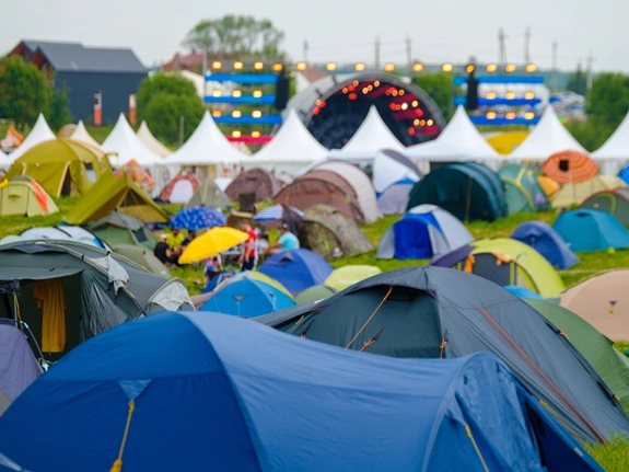 A field full of tents with an open-air stage in the background