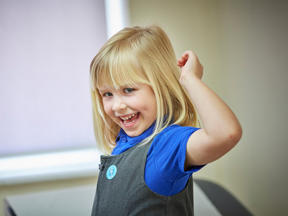 Young girl in a clinic celebrating with a sticker after getting her vaccination