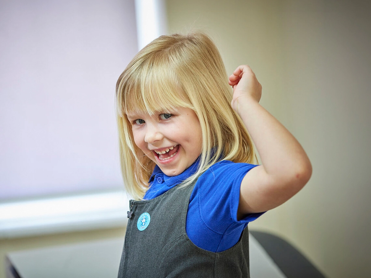 Young girl in a clinic celebrating with a sticker after getting her vaccination