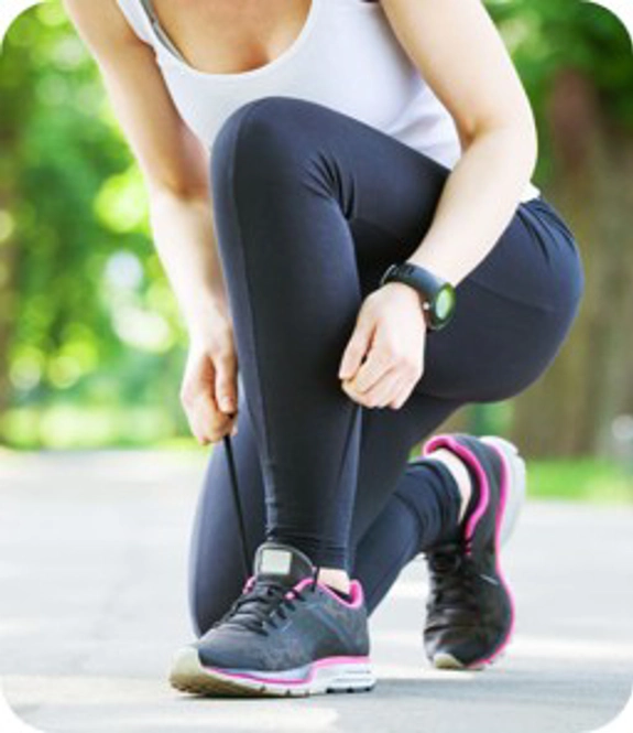 Woman lacing up running trainers