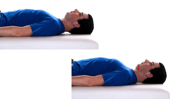Person lying with arms by their sides, tucking their chin inwards.