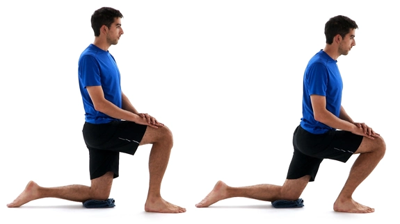 Person kneeling on a towel with one leg, while the other is in front of them, foot flat on the floor, and they're shifting their weight towards it.