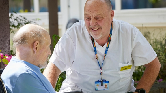 Male staff member looking at patient in wheelchair