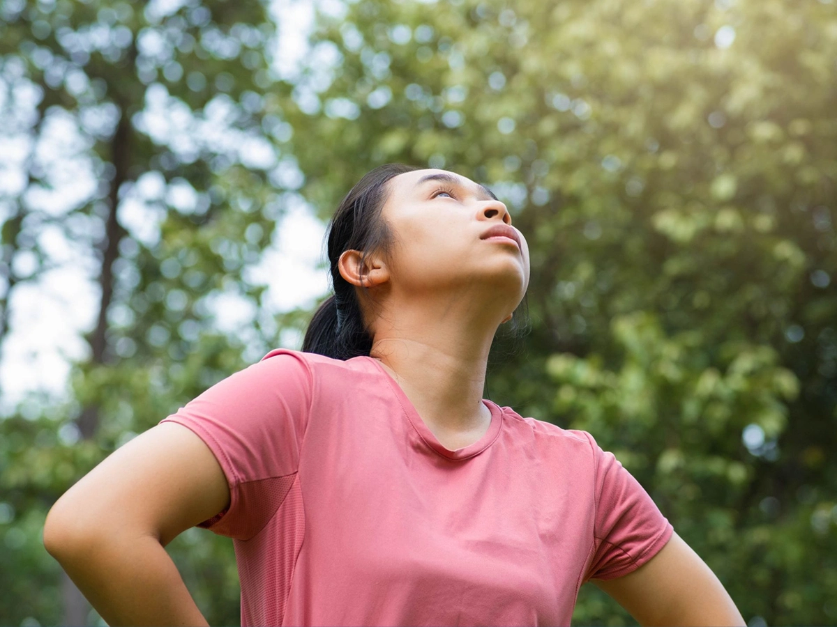 A person looking very hot and tired, looking at a sunny sky
