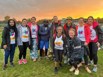 A group photo of 10 people, stood on a field smiling, at the end of the race day