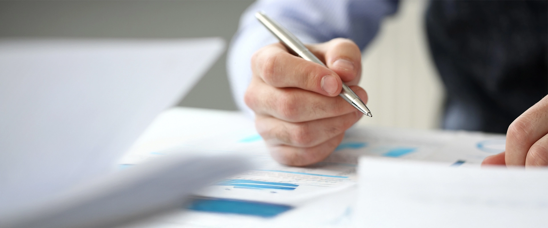 A closeup photo of hands writing on a report page