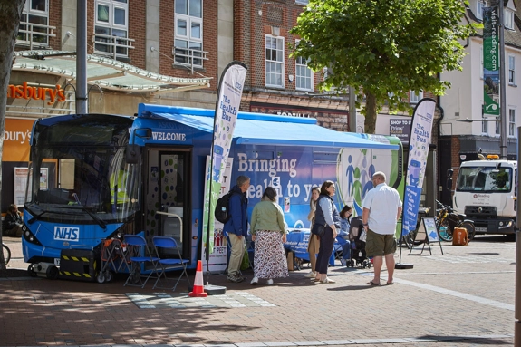 Community health bus with staff providing information and support to members of the public