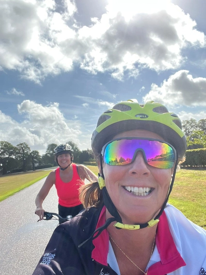A selfie of two team members, riding on bikes