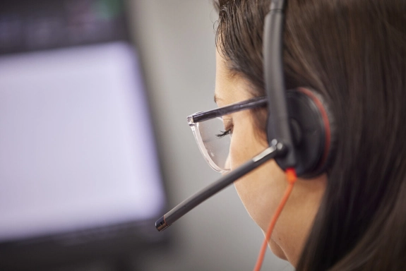 A closeup of a staff member wearing a phone headset