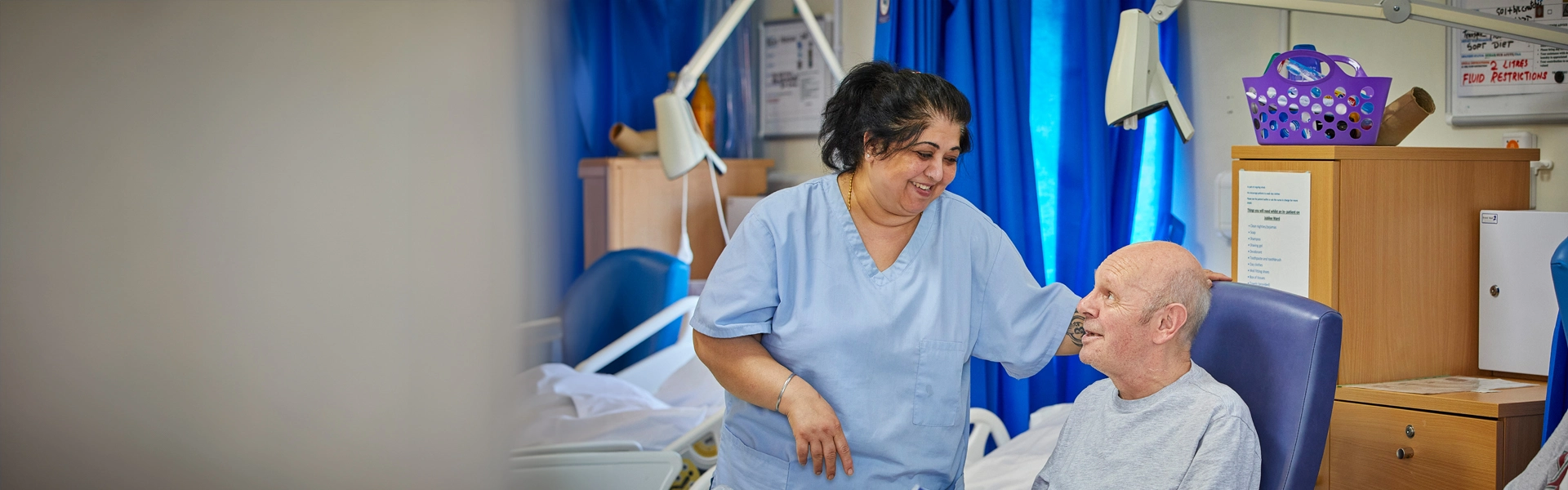 healthcare assistant with patient on ward