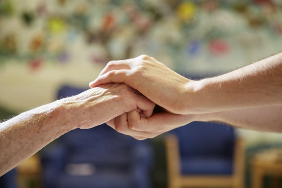 Holding Hands Supportively In Care Home