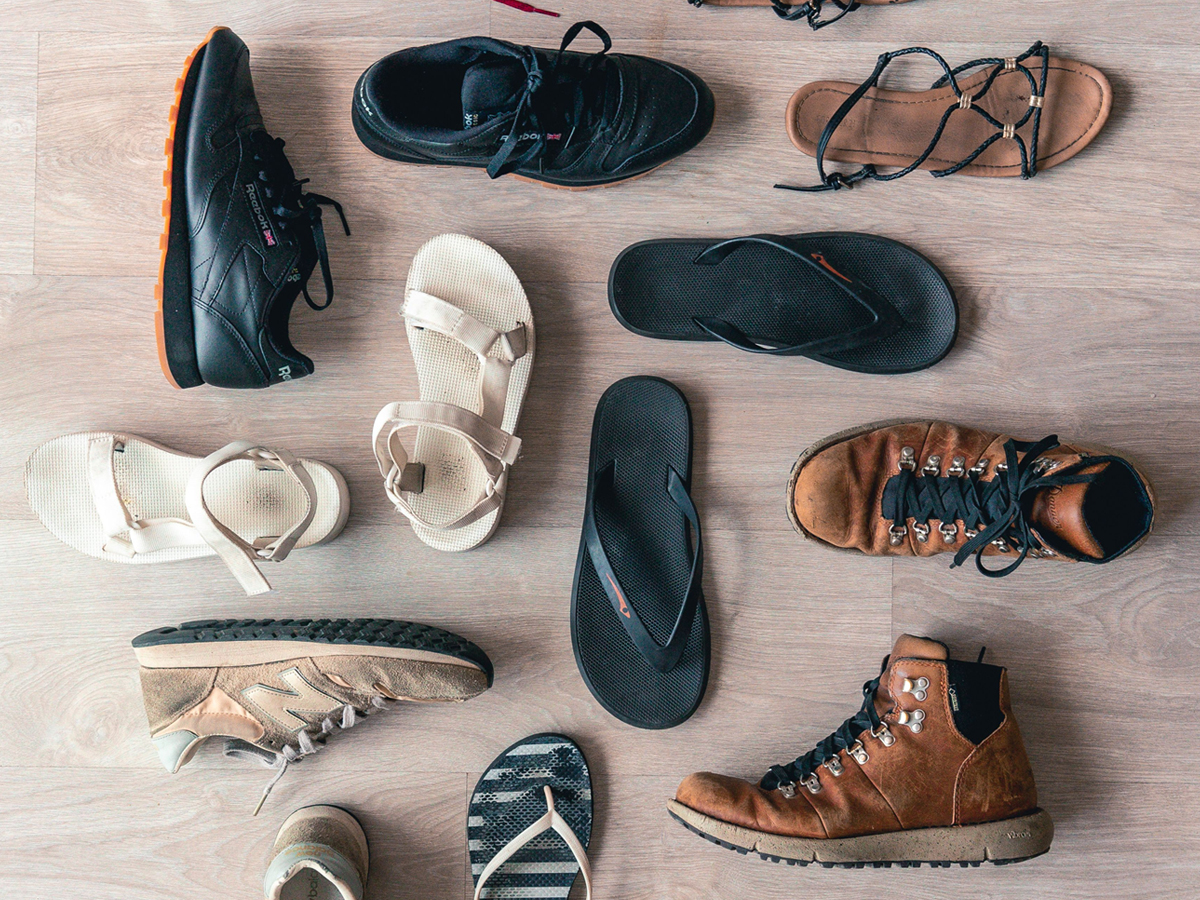 A range of types of shoes, including trainers, flip-flops, and sandals