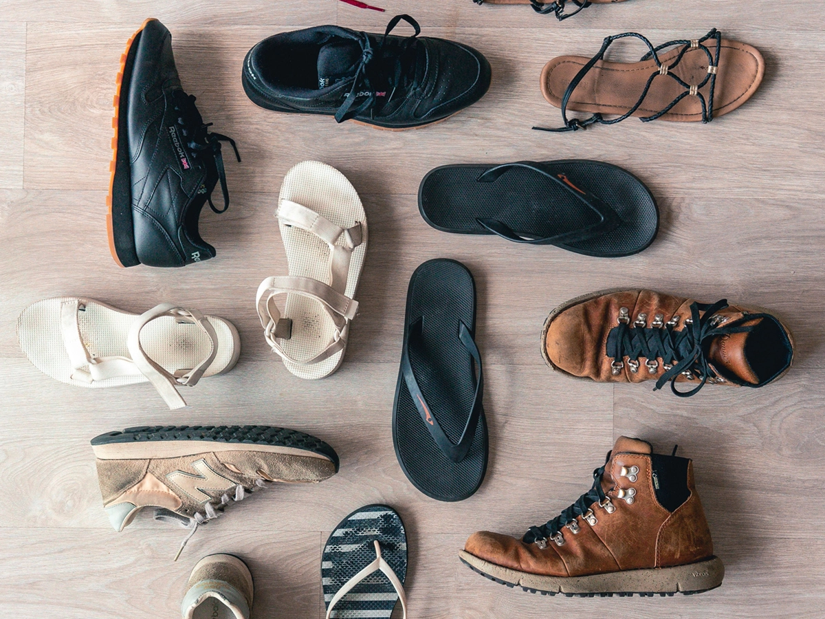 A range of types of shoes, including trainers, flip-flops, and sandals