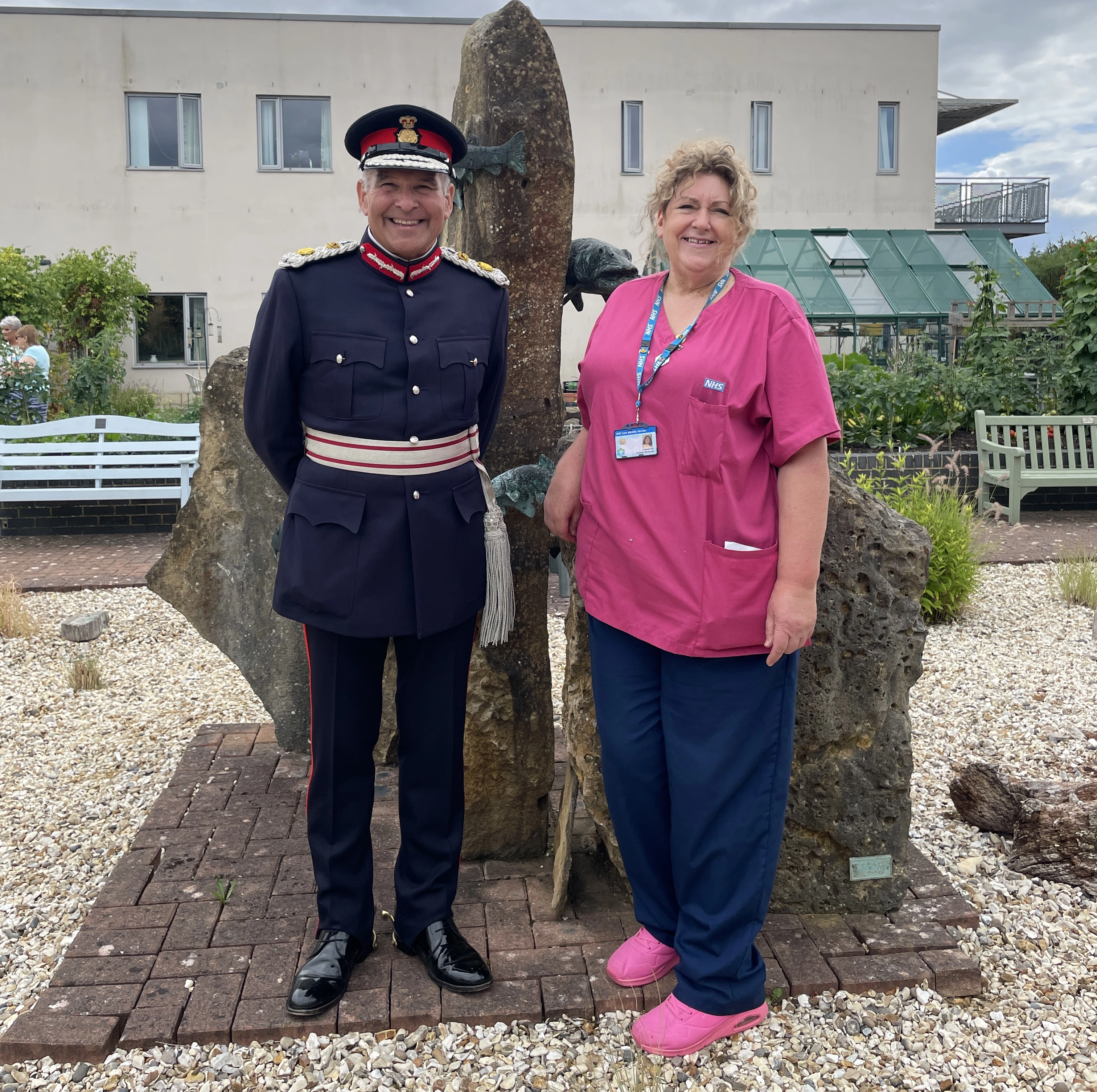 A Member Of Our Staff Standing Next To An Armed Forces Personnel