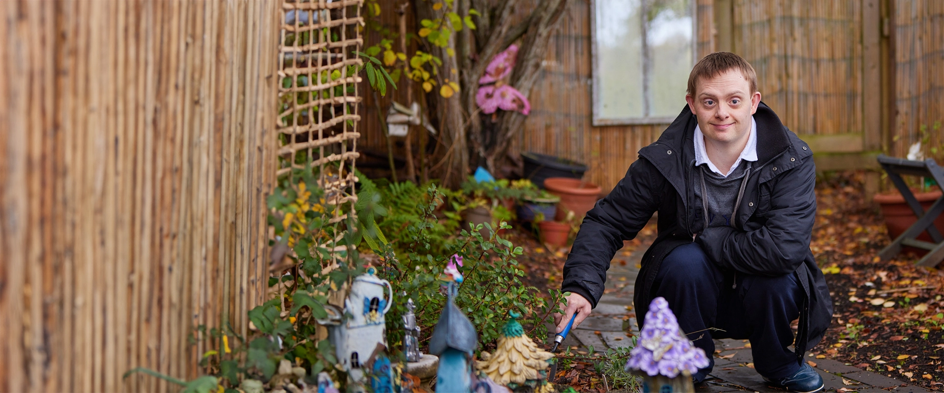Man with Down's syndrome smiling while gardening