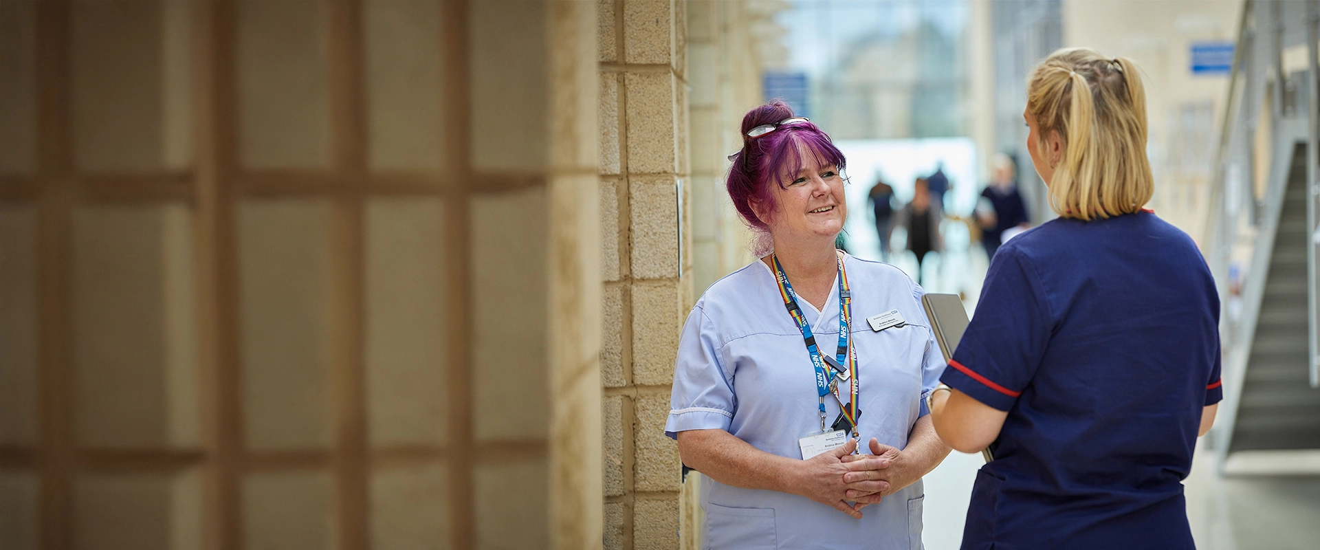 Two nurses talking in a hospital reception area