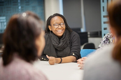 Staff member in meeting smiling around a table