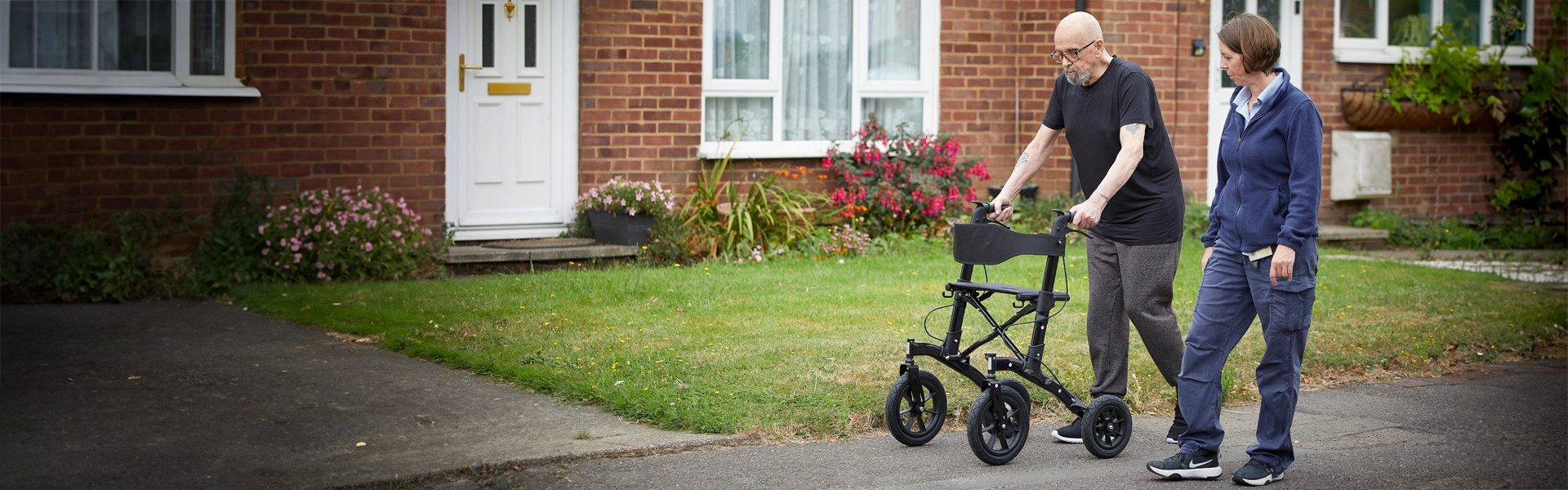 community physiotherapist with patient using walker by home