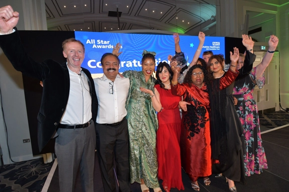 Photo of group of winners on stage with award