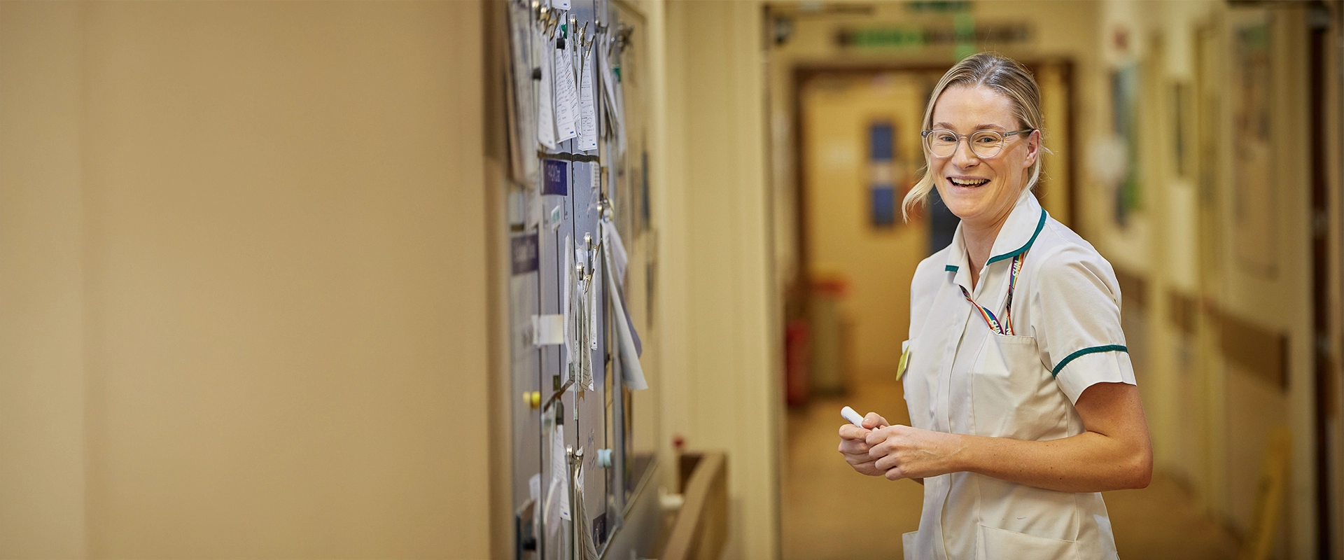 Nurse smiling next to board