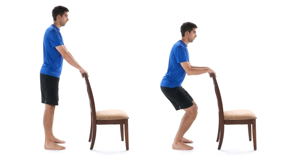 Person standing behind chair with both hands on the back, then bending knees and elbows while keeping back straight.