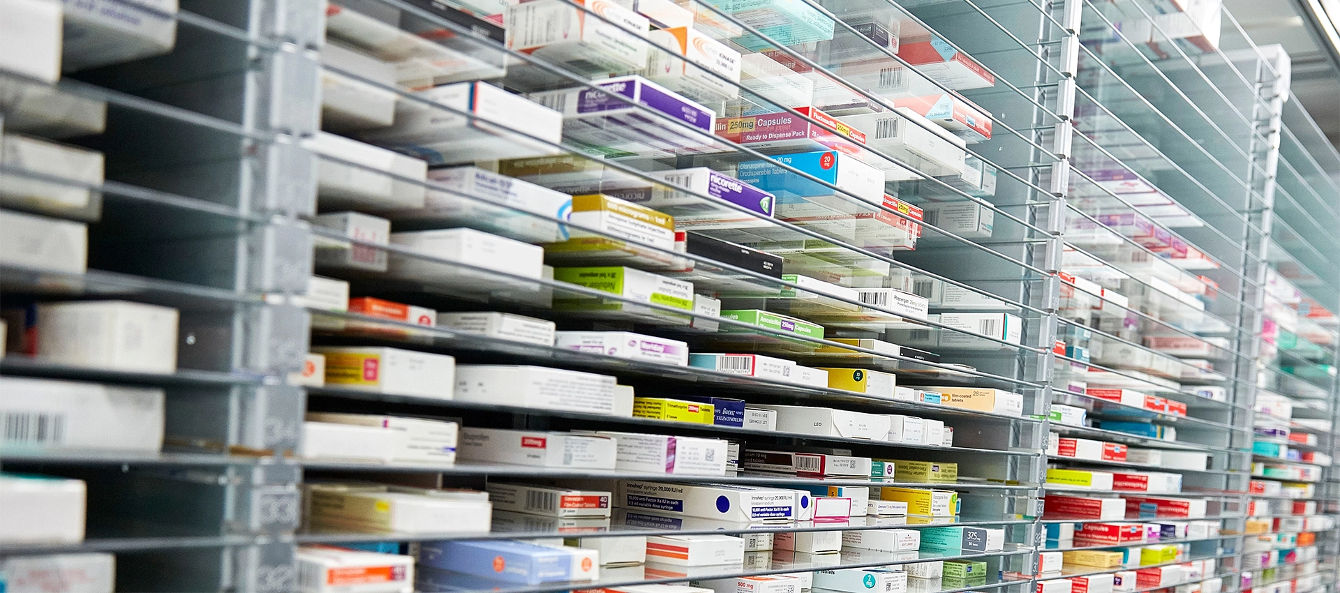Medicine boxes stored on the pills dispensary shelves in a pharmacy